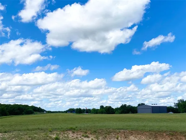 an aerial view of residential house with outdoor space and trees all around