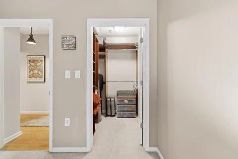 a view of a hallway view with wooden floor and living room