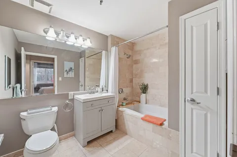 a bathroom with a tub sink vanity and mirror