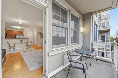 a kitchen with granite countertop a stove top oven a sink dishwasher a dining table and chairs with wooden floor