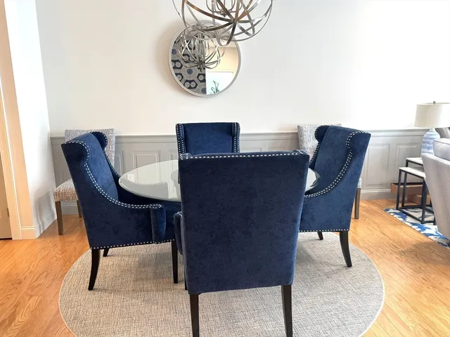 a view of a dining room with furniture a rug and wooden floor