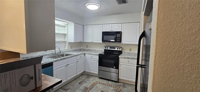 a kitchen with a sink appliances and cabinets