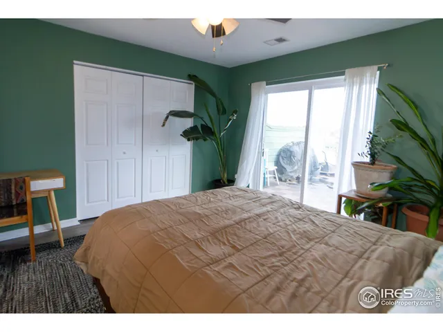 a bedroom with a bed a chair and a large window