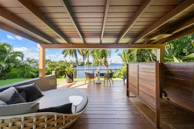 a view of a patio with a dining table and chairs with wooden floor