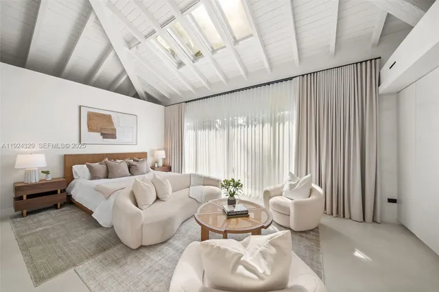 a spacious bedroom with furniture and a large window