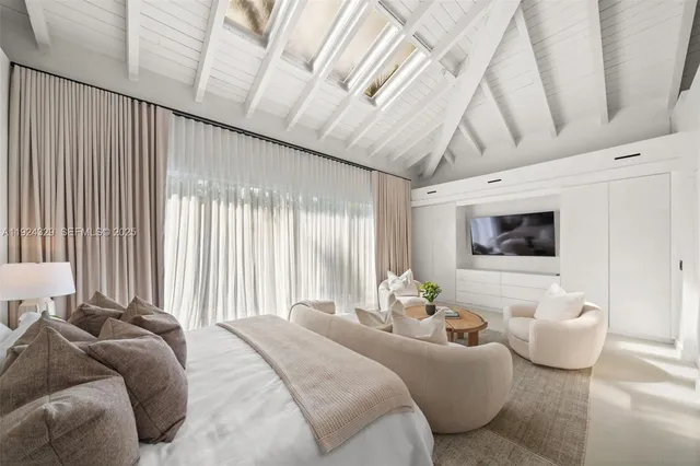 a bedroom with furniture and a flat screen tv