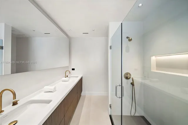 a bathroom with a double vanity sink a mirror and a bathtub