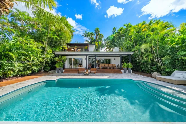 a view of house with garden and tall trees