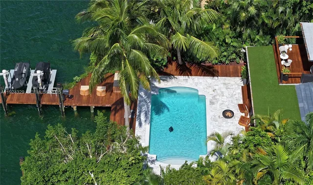 an aerial view of residential house with outdoor space and trees all around