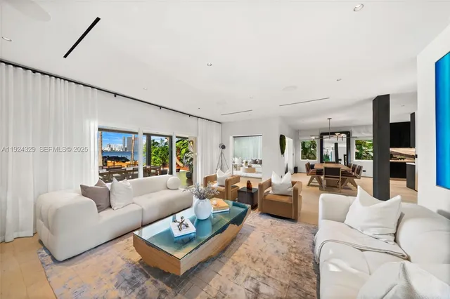 a living room with furniture a flat screen tv and a large window