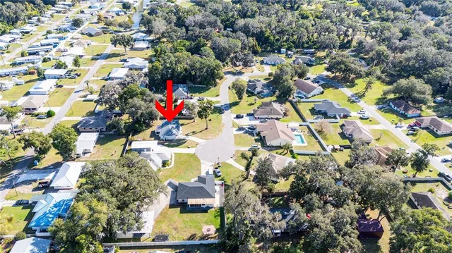 an aerial view of residential houses with outdoor space and trees all around
