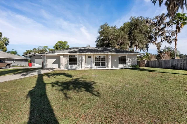 a view of a house with pool plants and large trees