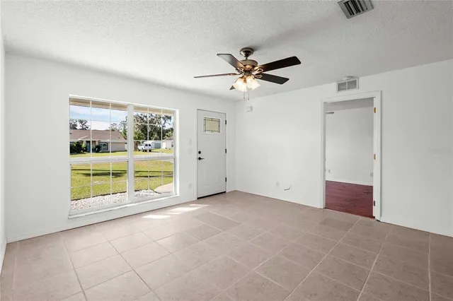 a view of a livingroom with a ceiling fan and window