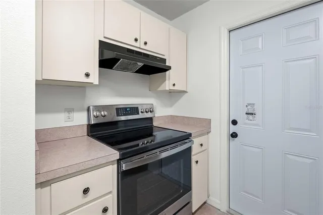 a kitchen with stainless steel appliances granite countertop white cabinets and a stove