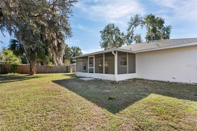 a view of a house with a yard and tree