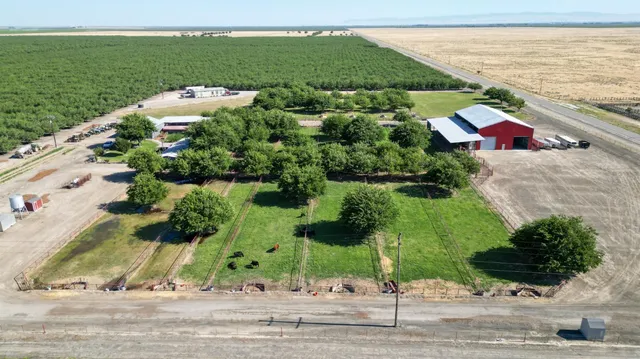 an aerial view of a house with a yard and lake view