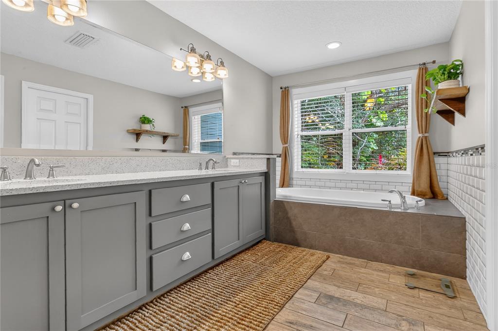 1795 Brumley Road Chuluota, FL 32766 - Photo 16 of 41 a spacious bathroom with a granite countertop sink a mirror and a bathtub