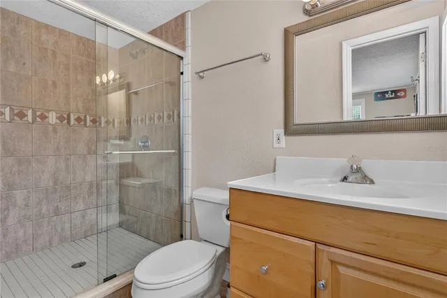 a bathroom with a sink toilet vanity and shower