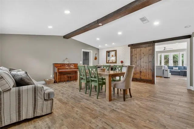a living room with furniture a wooden floor and next to a window