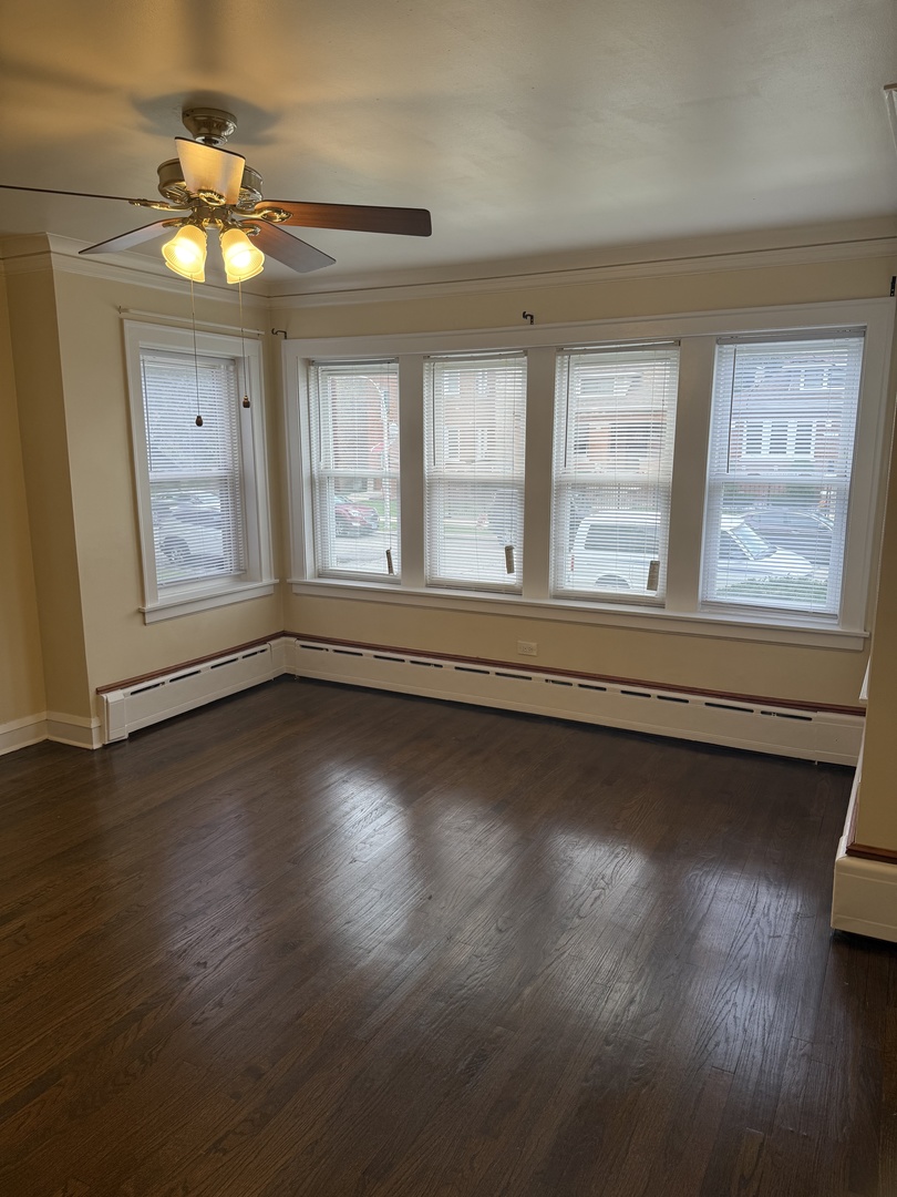 1641 North Merrimac Avenue, Unit 1 Chicago, IL 60639 - Photo 3 of 5 an empty room with wooden floor and windows
