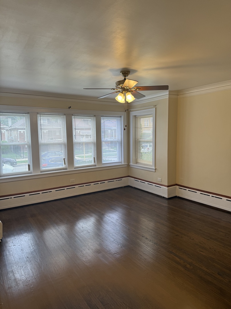 1641 North Merrimac Avenue, Unit 1 Chicago, IL 60639 - Photo 5 of 5 an empty room with wooden floor and windows