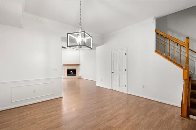 a view of empty room with wooden floor and fireplace