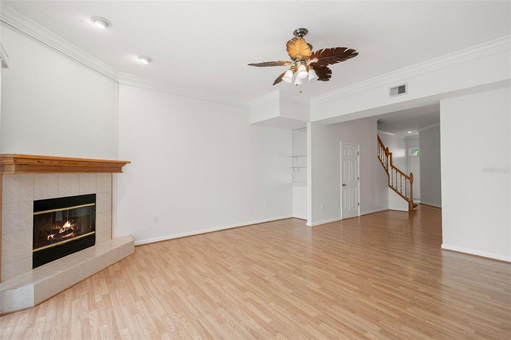 1644 Arabian Lane Palm Harbor, FL 34685 - Photo 17 of 52 a view of an empty room with a fireplace and a ceiling fan