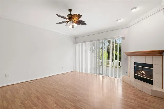 a view of an empty room with a fireplace and a window