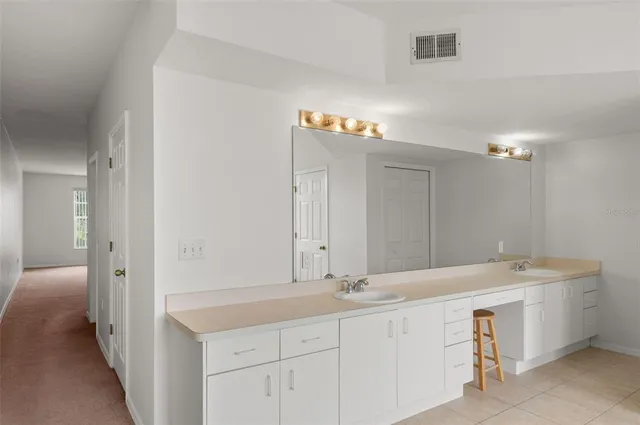 a bathroom with a double vanity sink and a mirror