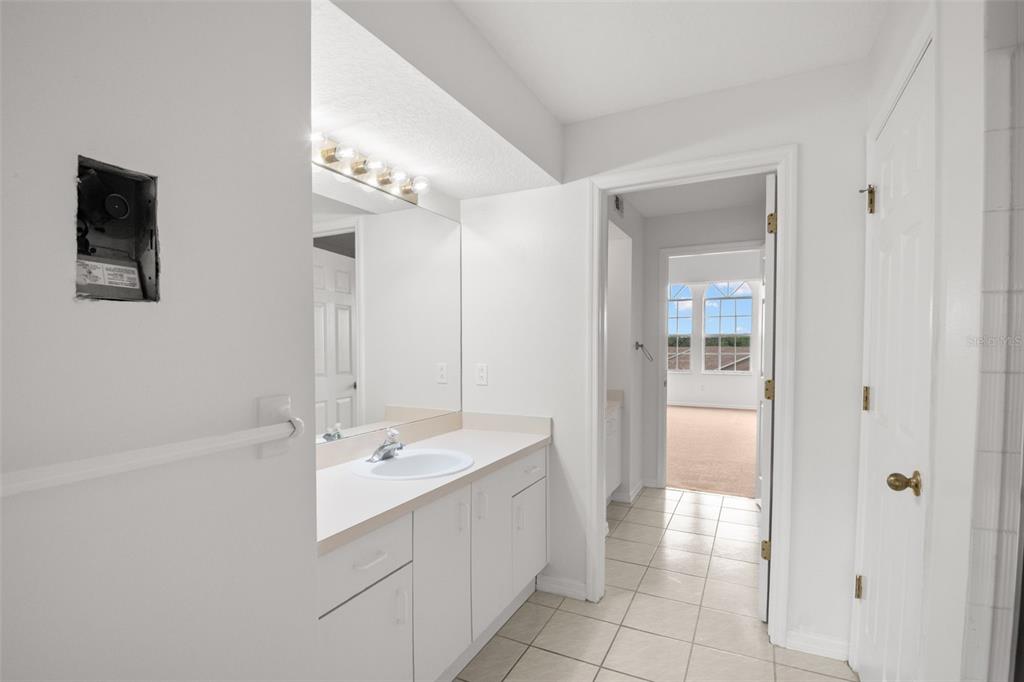 1644 Arabian Lane Palm Harbor, FL 34685 - Photo 36 of 52 a bathroom with a double vanity sink a mirror and a bathtub