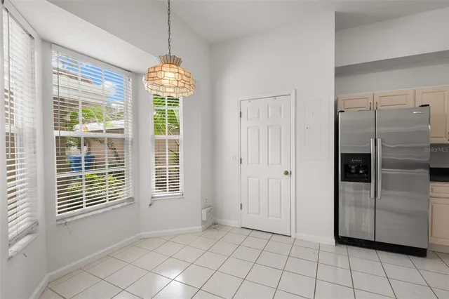 a view of an empty room with window and chandelier