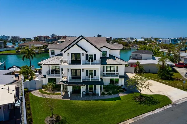 a view of a house with swimming pool lawn chairs and a fire pit