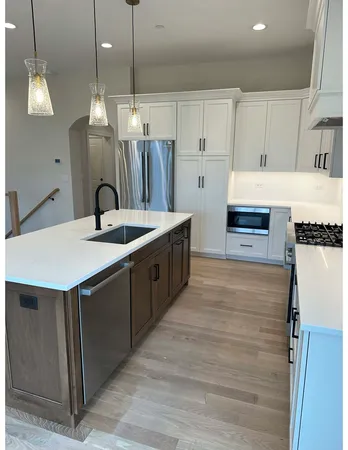 a kitchen with stainless steel appliances granite countertop a sink a stove and a refrigerator
