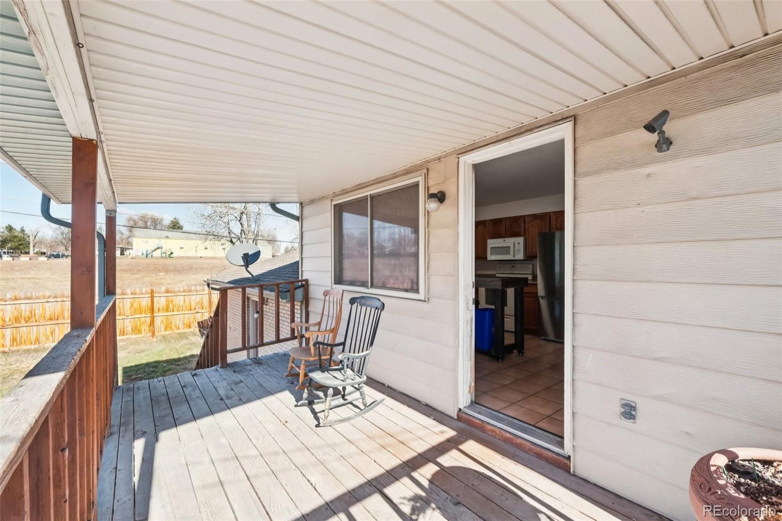 6277 Reed Court Arvada, CO 80003 - Photo 13 of 40 a balcony with chairs and wooden floor