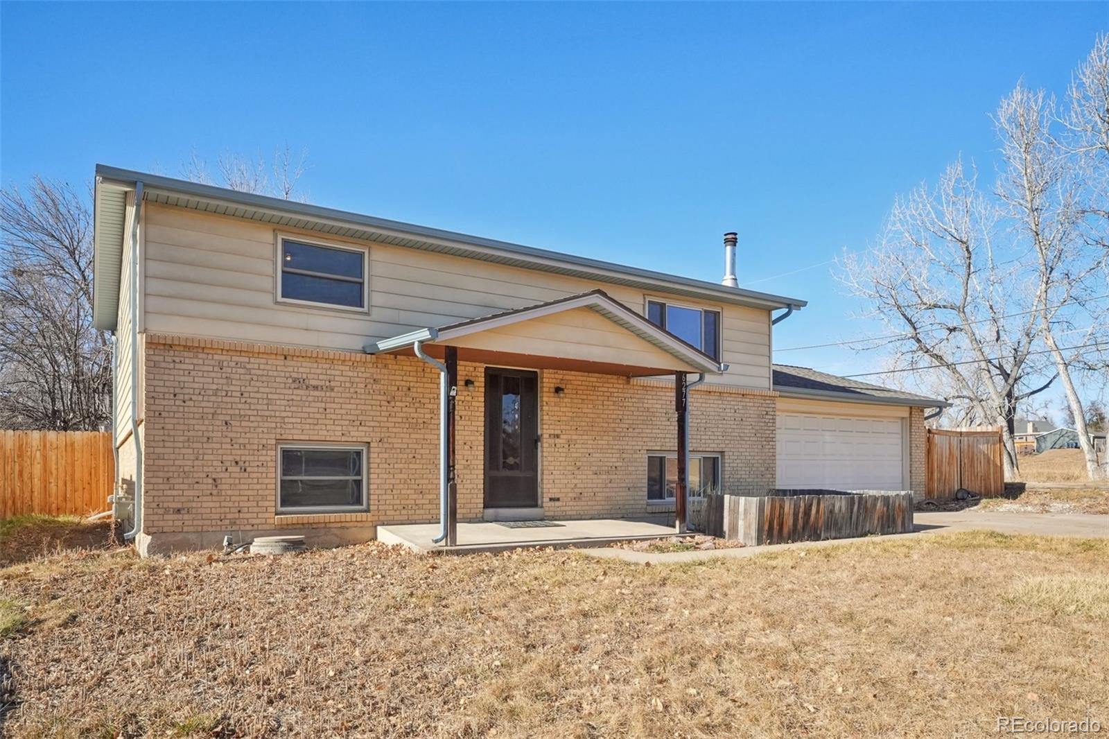 6277 Reed Court Arvada, CO 80003 - Photo 2 of 40 a front view of a house with a yard and garage