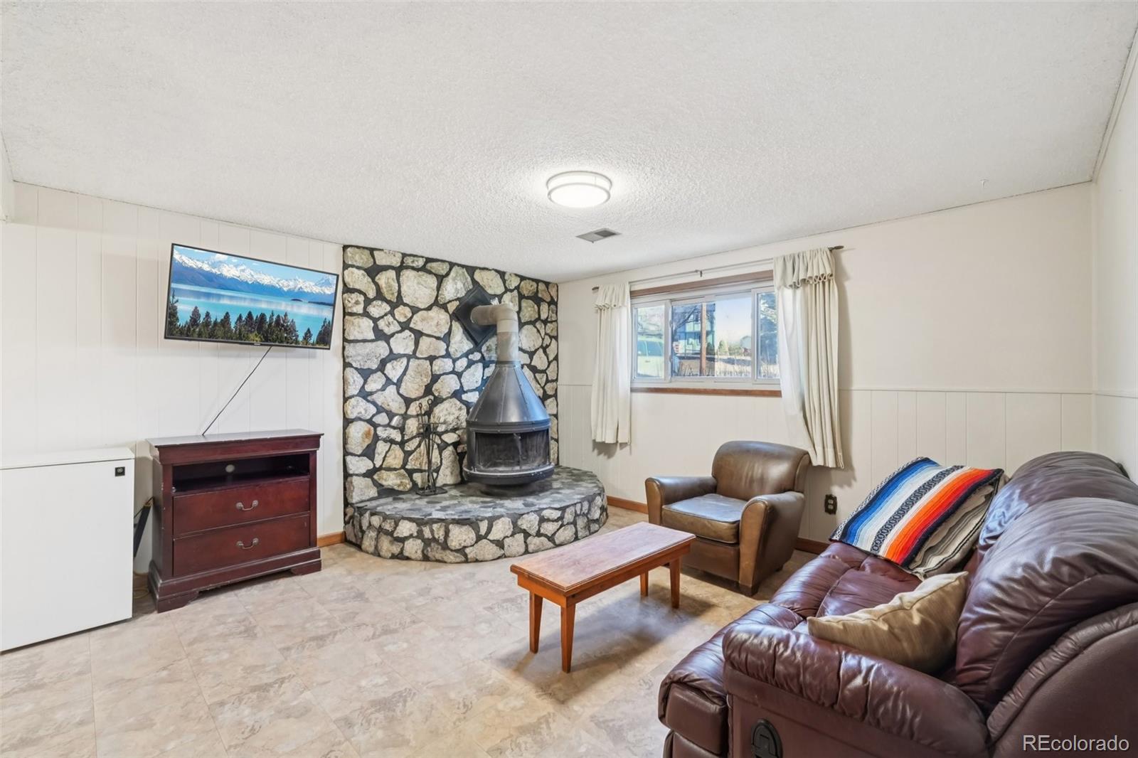 6277 Reed Court Arvada, CO 80003 - Photo 26 of 40 a living room with furniture a rug and a wall painting