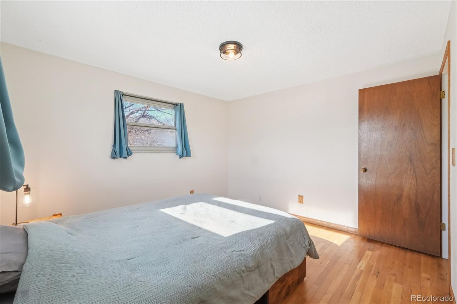 6277 Reed Court Arvada, CO 80003 - Photo 27 of 40 a bedroom with a bed and wooden floor