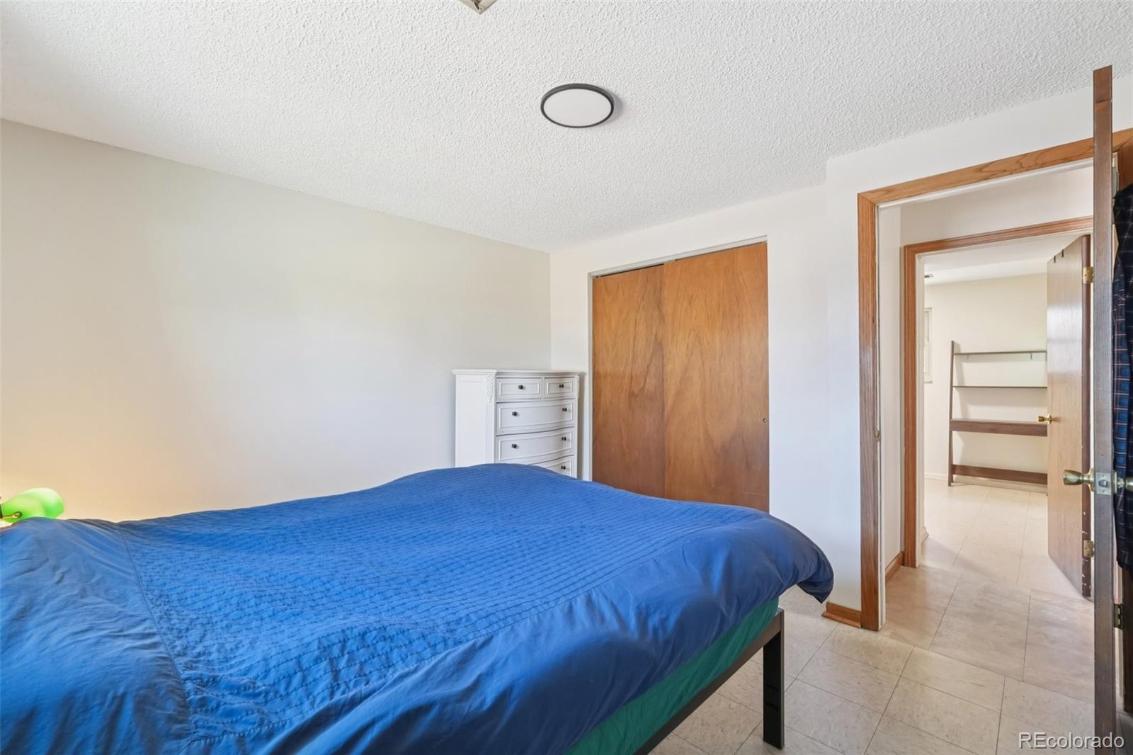 6277 Reed Court Arvada, CO 80003 - Photo 32 of 40 a bedroom with a bed and a painting on the wall