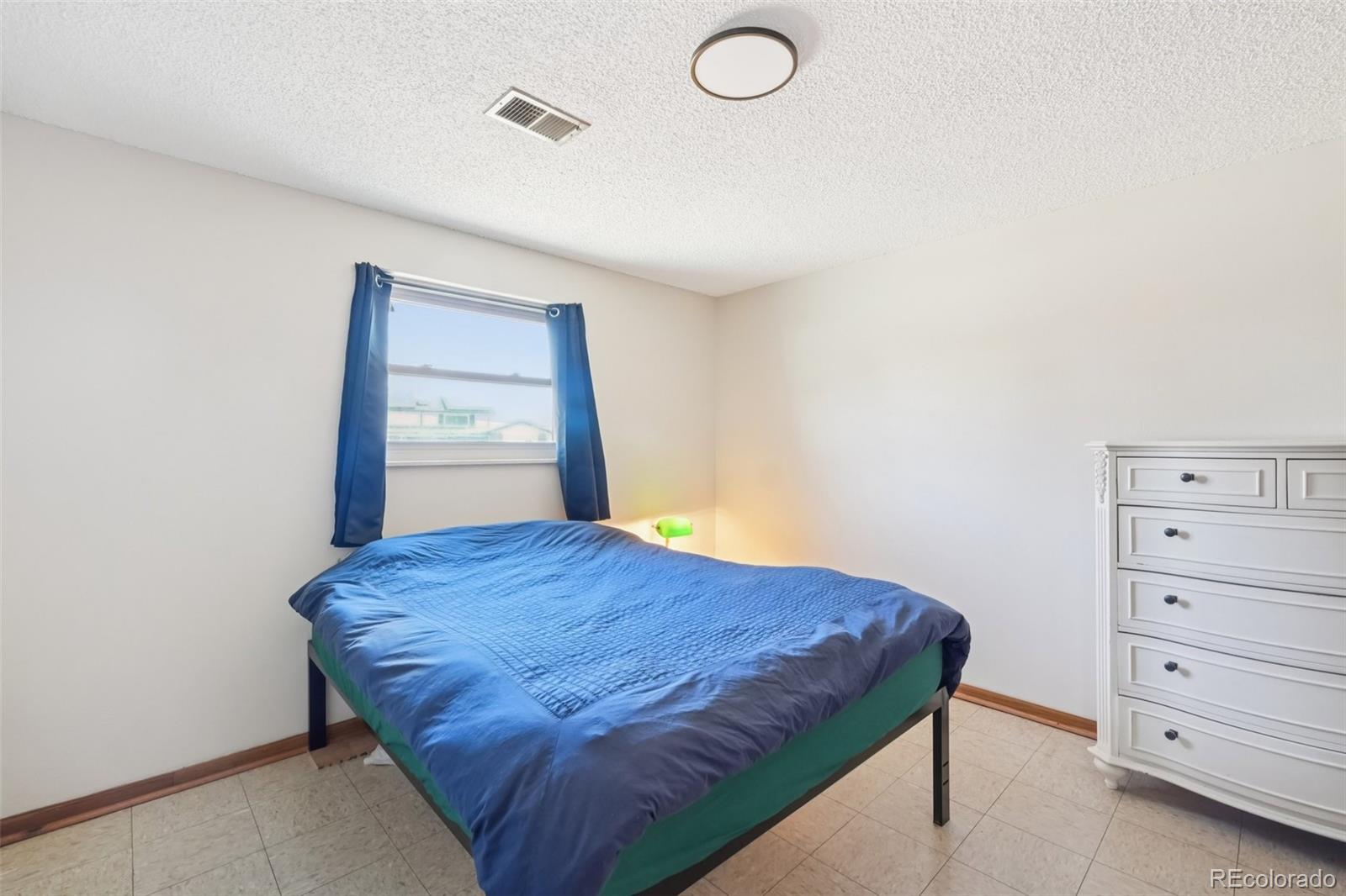 6277 Reed Court Arvada, CO 80003 - Photo 34 of 40 a bedroom with a bed and cabinet