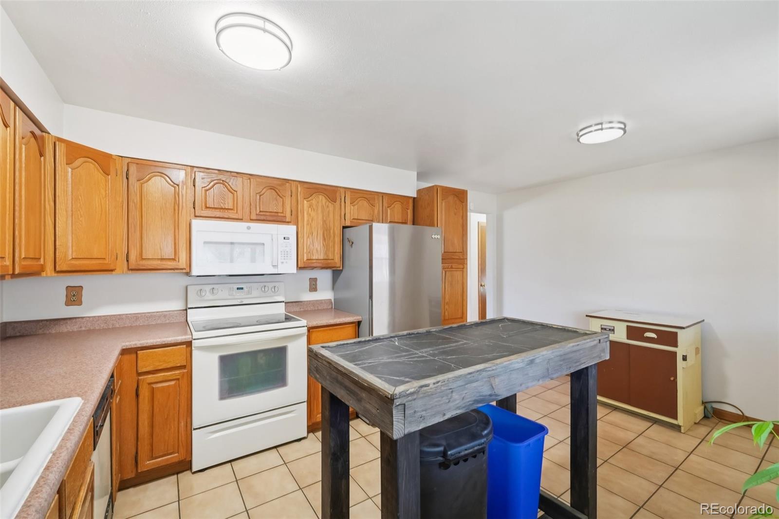 6277 Reed Court Arvada, CO 80003 - Photo 6 of 40 a kitchen with a stove a sink and a refrigerator