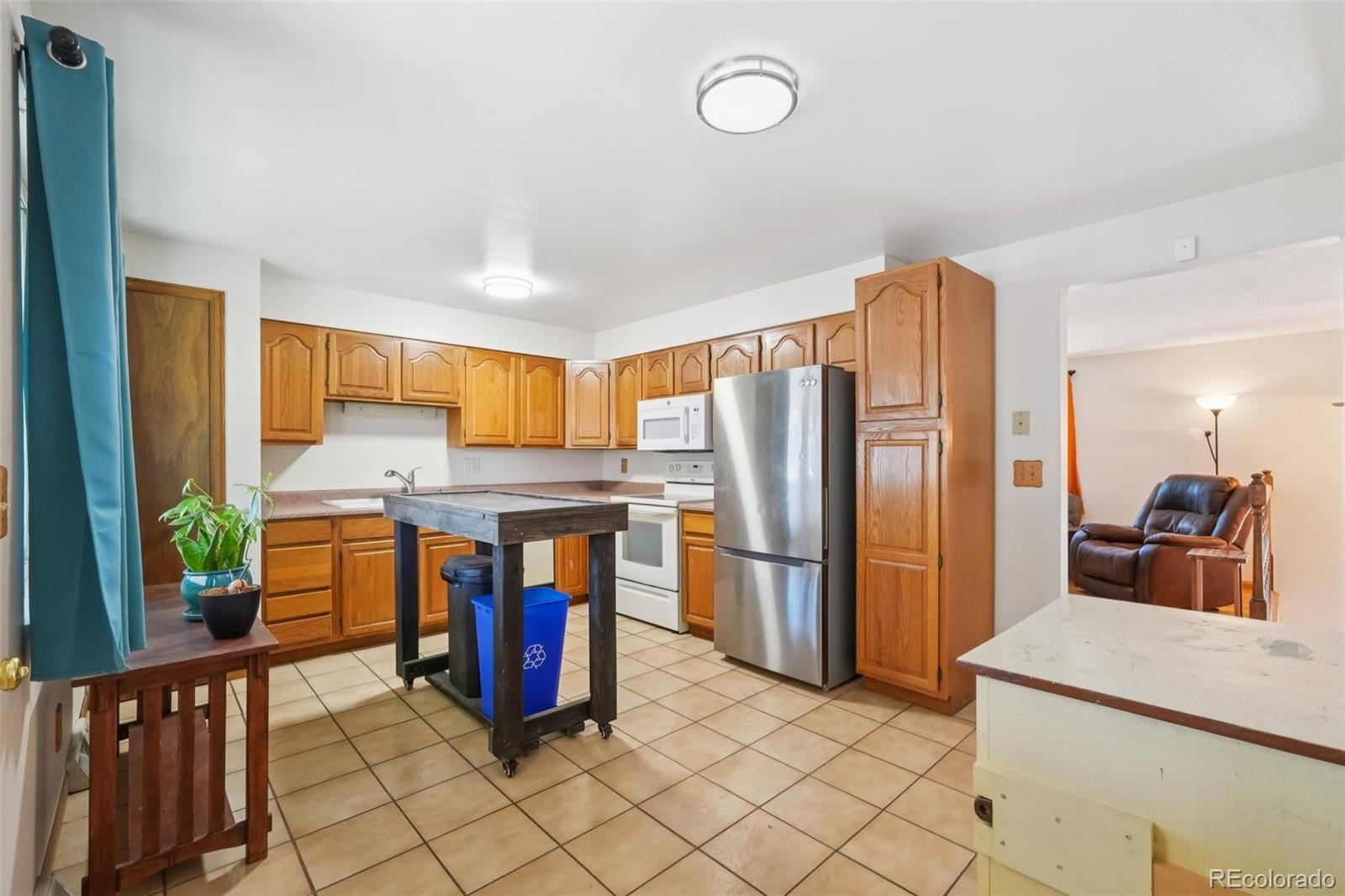 6277 Reed Court Arvada, CO 80003 - Photo 8 of 40 a kitchen with stainless steel appliances granite countertop a refrigerator and a stove