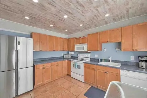 a kitchen with a sink appliances cabinets and furniture