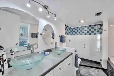 a bathroom with a double vanity sink mirror and shower