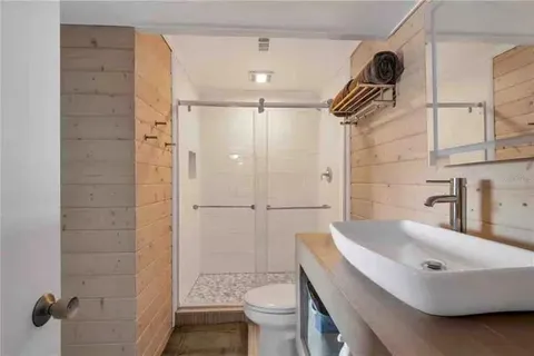 a bathroom with a sink a toilet and shower