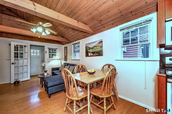 a kitchen with stainless steel appliances granite countertop a refrigerator a stove and a sink with wooden floor