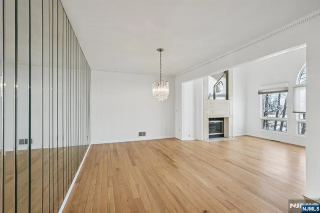 a view of empty room with wooden floor and fireplace