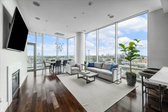a living room with furniture floor to ceiling window and wooden floor