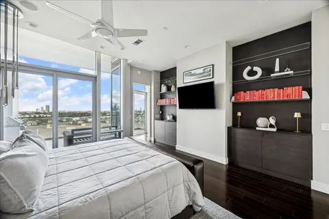 a bedroom with a bed and a flat tv screen on the dresser