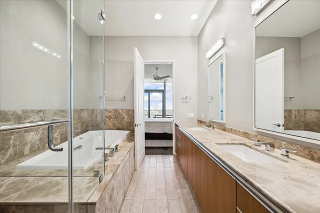 a spacious bathroom with a granite countertop sink a large mirror and shower