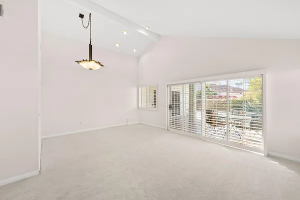 an empty room with fireplace and windows